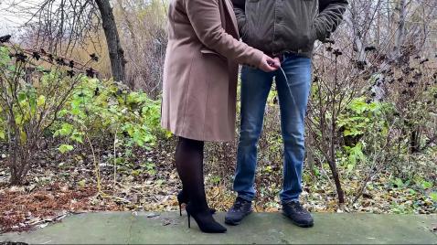 Жена в черных чулках гуляет с мужем на улице